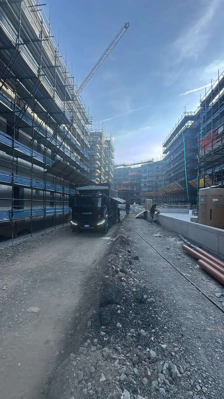 Mezzo di cantiere tra gli edifici con ponteggi