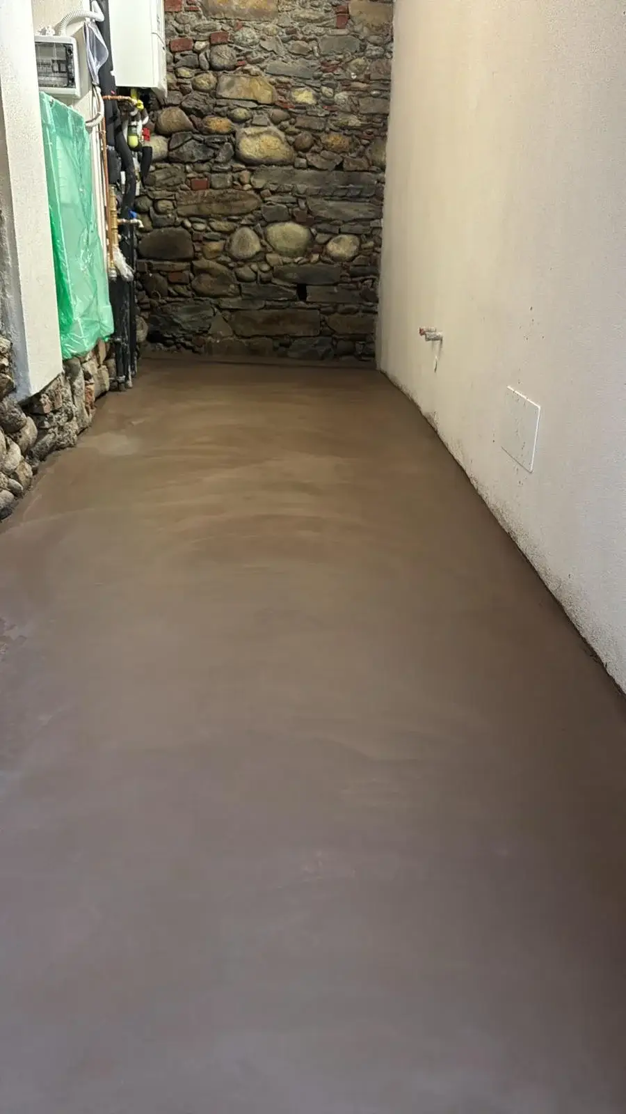 Nuovo massetto accanto a una parete in pietra