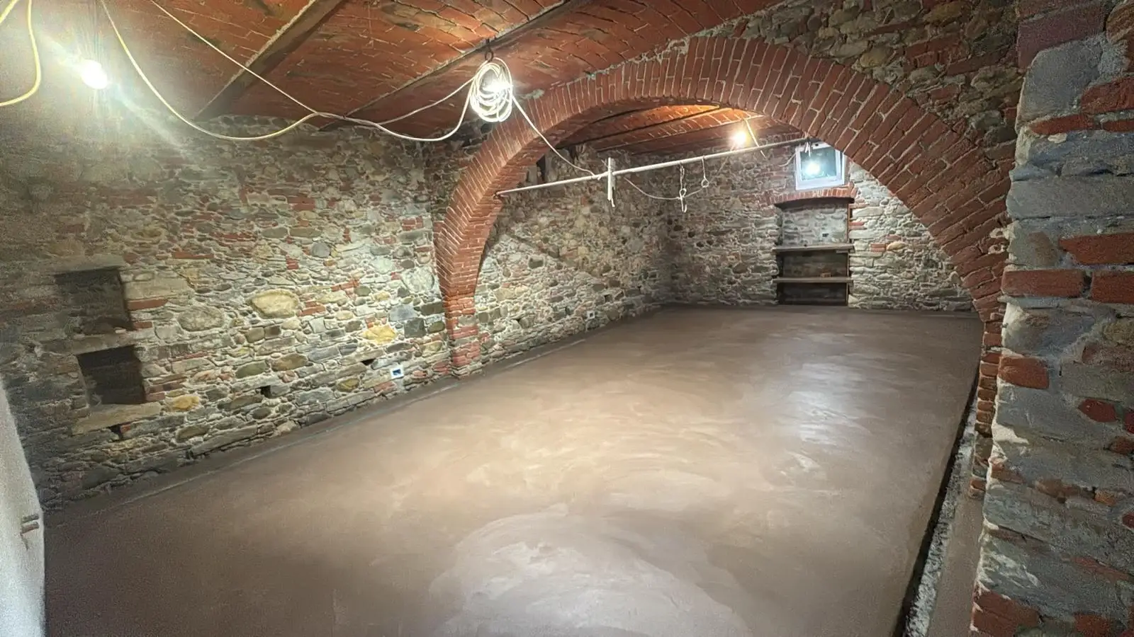 Superficie del massetto in un ambiente con pareti in pietra